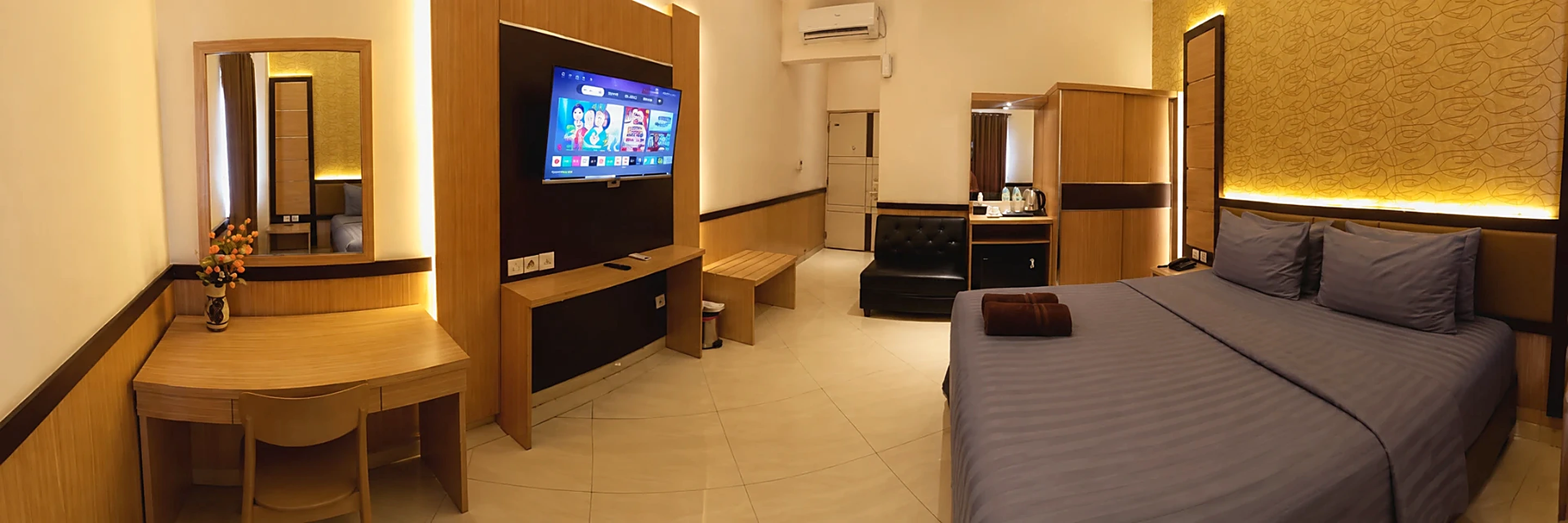 Spacious guest room with a double bed, work desk, wardrobe and TV at Paris Day Hotel Pamanukan